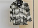 a black and white jacket hanging on a clothes rack in a room