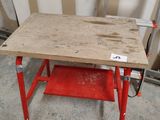 a red work bench with a wooden top in a garage