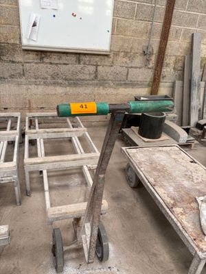 une table sur laquelle repose un marteau, au milieu d'une pièce