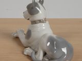 a white and gray dog figurine sitting on a table