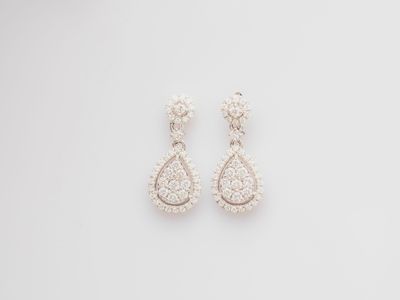 a pair of diamond earrings on a white background