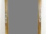 une image représentant un grand miroir à cadre doré posé sur un parquet