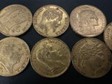 six different british coins sitting on top of a black surface