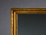 a mirror with a gold frame on the wall