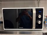 a man taking a picture of himself in the mirror of a microwave