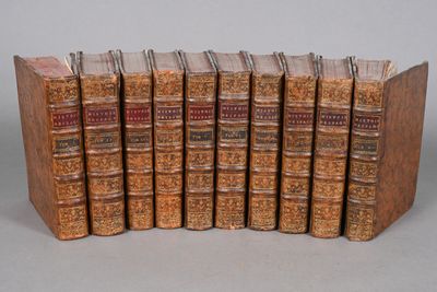 six old books are stacked on top of each other on a table