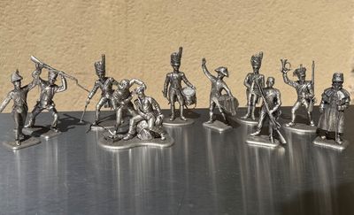 silver figurines of soldiers with spears and shields on a table