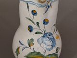 a white vase with blue and yellow flowers on it