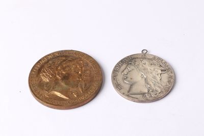 two coins are shown next to each other on a white surface