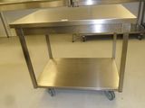 une table en acier inoxydable avec un tiroir en dessous