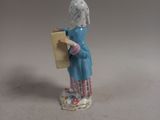 a figurine of a woman holding a piece of paper