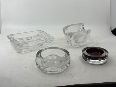 a glass ashtray, a glass ashtray, and a glass ashtray on a table