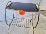 a small metal shelf with a black top on a white background