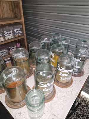 de nombreux bocaux en verre posés sur une table dans une pièce
