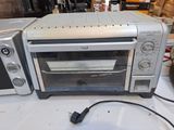 a toaster oven sitting on a table with a cord in front of it