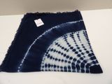 a close up of a blue and white tie dyed scarf on a table