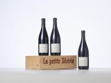 three bottles of wine sit in front of a wooden box