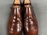 a pair of brown leather shoes on a grey surface