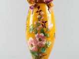 yellow vase with pink flowers on it on a white background