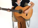 a woman sitting on a chair holding a guitar