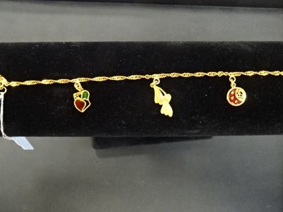 Gros plan sur un bracelet en or orné de breloques