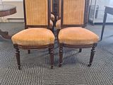 three chairs with upholstered back cushions in a room with a table and chairs