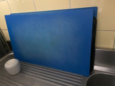 une planche à découper bleue posée sur un plan de travail de cuisine