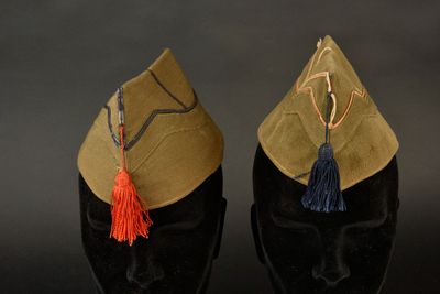 deux chapeaux ornés de pompons, posés sur une tête de mannequin