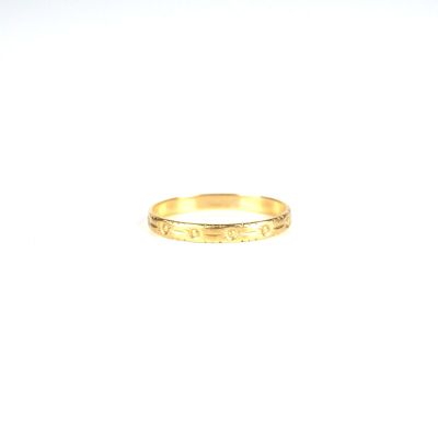 gros plan d'une bague en or sur une surface blanche