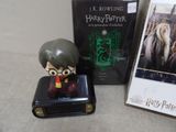 a small figurine of harry potter sitting on top of a suitcase