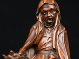 wooden statue of a woman riding a horse with a man on the back