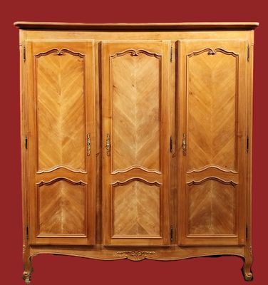 une armoire en bois à trois portes et deux tiroirs