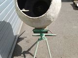 a cement mixer sitting on a stand in front of a building