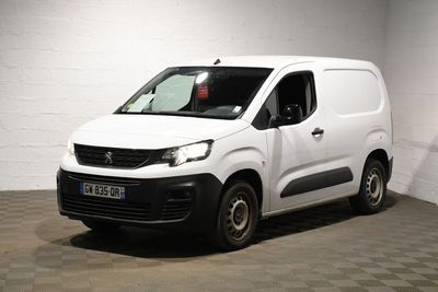 la camionnette blanche est garée dans une grande pièce au sol en damier