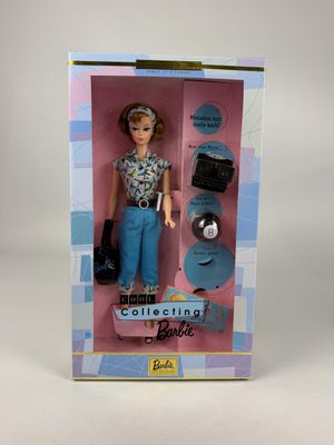 La poupée Barbie se trouve dans une boîte qui contient son contenu.