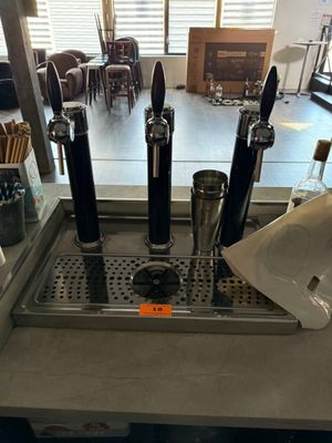 a counter with a bunch of beer taps on it