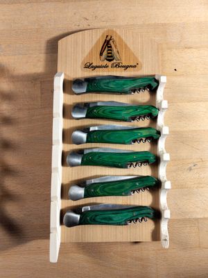 five knives and a knife holder on a wooden table