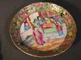 a plate with a painting on it sitting on a table