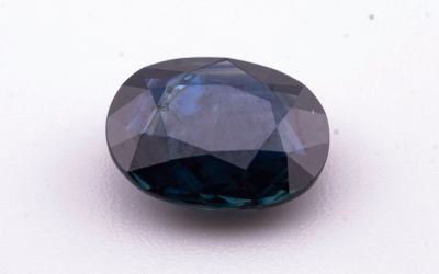 un gros plan d'un diamant bleu sur une surface blanche