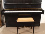 a black piano and a stool in a room