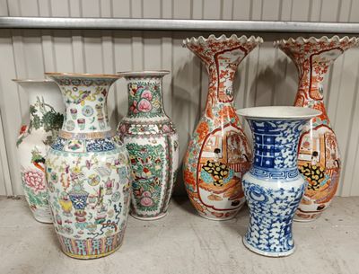 Plusieurs vases sont alignés sur une étagère dans une pièce