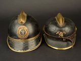 two helmets that are sitting side by side on a black surface