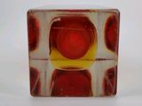 a glass block with a red and yellow design on it