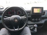 steering wheel of a car with a person sitting in the driver ' s seat in front of the steering wheel