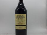 une bouteille de vin rouge posée sur une table blanche