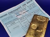 un gros plan sur un morceau d'or à côté d'un ticket de caisse