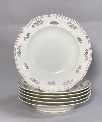 plusieurs assiettes empilées les unes sur les autres, ornées de fleurs roses