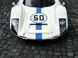 a white race car with blue stripes parked on a cobblestone street