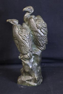 a statue of two birds sitting on a tree branch