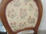 a wooden chair with a floral upholstered seat and back